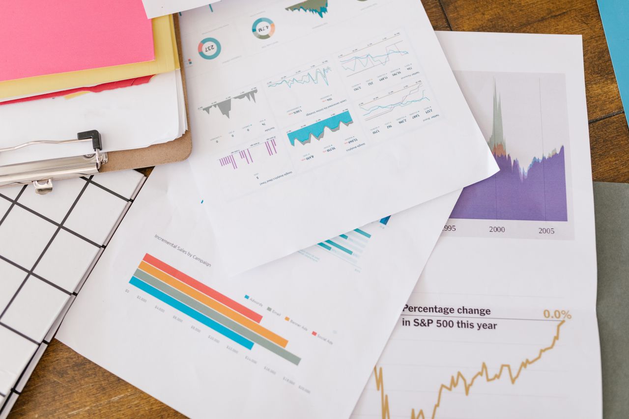 about-01 Close-up of business analytics charts and graphs on papers and clipboard.